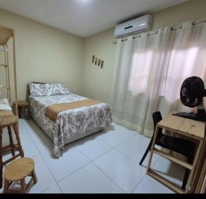 a bedroom with a bed and a table and a desk at Casa Brisas 17 in Luis Correia