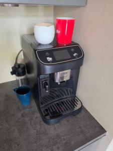 a coffee maker with a red cup on a counter at Appartment on Dorpsstraat in Bleskensgraaf