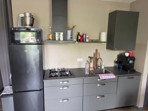 a kitchen with a stainless steel refrigerator and a microwave at Appartment on Dorpsstraat in Bleskensgraaf