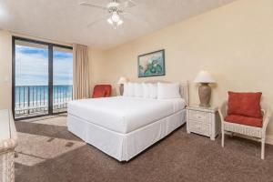 a bedroom with a white bed and a balcony at Phoenix X 317 in Orange Beach