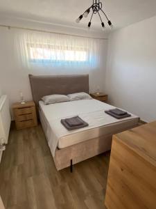 a bedroom with a bed with white sheets and wooden floors at Rifugio Blu in Costinesti