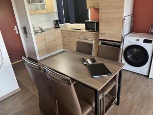 a kitchen with a wooden table and chairs and a washer at schönes Apartment mit Festungsblick - FREE Parking - in Würzburg