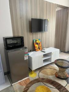a living room with a television and a refrigerator at Edwin homes in Nairobi