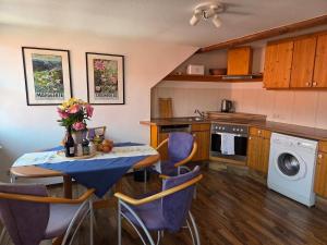 a kitchen with a table with purple chairs and a washing machine at Ferienwohnung Saskia in Hammelburg +8 photos