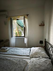 a bedroom with two beds and a window at Holiday Home Olivetree Rab in Supetarska Draga