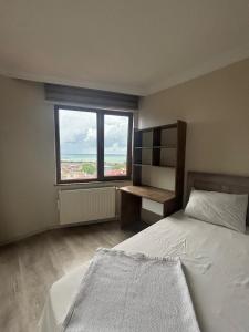 a bedroom with a bed and a window at SİMGE Apt in Trabzon