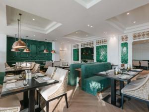 a restaurant with green walls and tables and chairs at Sofitel Ras Al Khaimah Al Hamra Beach Resort in Ras al Khaimah