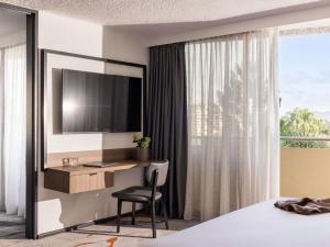 a hotel room with a desk and a television at Mercure Brisbane Spring Hill in Brisbane +56 photos