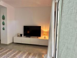 a living room with a flat screen tv on a white cabinet at Onda in Denia