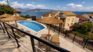 a balcony with a swimming pool and umbrellas at 3L Apartment and Studio in Nikiana