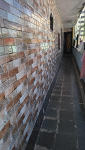 a brick wall next to a hallway in a building at C Gowri Lodge in Vellore