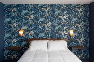 a bedroom with a bed with a blue floral wallpaper at Shelburne Springs Hotel in Shelburne Falls
