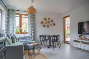a living room with a couch and a table and chairs at Apartament Roberto in Żarnowska