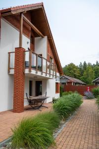 a house with a balcony and a patio at Apartament Roberto in Żarnowska