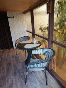a table and two chairs on a porch at Синие домики in Borovoye