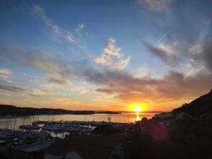 a sunset over a harbor with boats in the water at Holiday Home Olivetree Rab in Supetarska Draga
