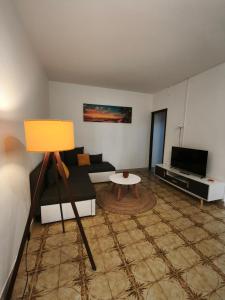 a living room with a couch and a tv at Holiday Home Olivetree Rab in Supetarska Draga