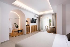 a bedroom with a bed and a living room at Oliving Mykonos Luxury Suites in Klouvas