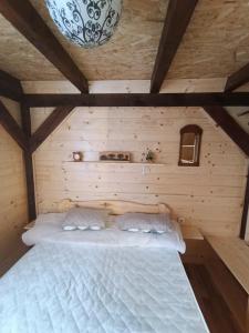 a bed in a room with a wooden wall at Stevanova brvnara in Zlatibor