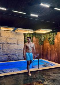 a man is standing in a hot tub at Hotel Litworowy Staw in Białka Tatrzańska