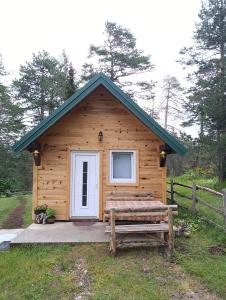 a log cabin with a white door and a bench at Stevanova brvnara in Zlatibor