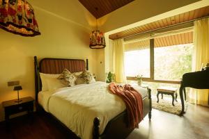 a bedroom with a bed and a large window at MONKEY RESORT in McLeod Ganj +12 photos