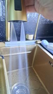 a person holding a knife over a kitchen sink at APPLE PARADISE, House of mirrors, self check-in, FREE PARKING in Riga