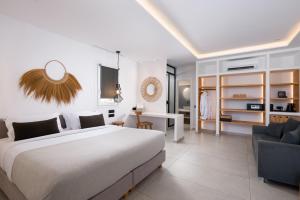 a bedroom with a large bed and a desk at Oliving Mykonos Luxury Suites in Klouvas +215 photos
