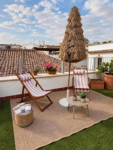 a patio with a umbrella and two chairs and a table at Hotel Suite Generis in Córdoba