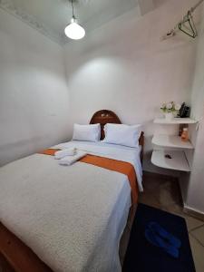 two beds in a room with white walls at holm's home studio in Diani Beach