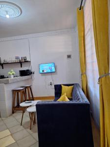 a living room with a couch and a tv at holm's home studio in Diani Beach