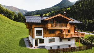 a wooden house with a balcony on a hill at Antenbachhof in Grossarl