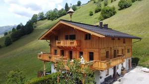 a wooden house with a balcony on a hill at Antenbachhof in Grossarl