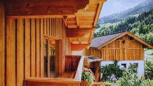 a wooden house with a staircase leading up to it at Antenbachhof in Grossarl