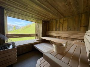 a sauna with a large window and a tub at Antenbachhof in Grossarl