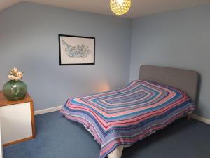 a bedroom with a bed with a colorful blanket on it at Character Cottage in Wallingford in Wallingford