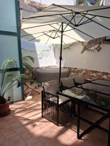 a table and chairs under an umbrella on a patio at Appartamento Claudia in Roccalumera