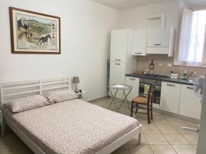 a small bedroom with a bed and a kitchen at Renaio House Buti in Bientina