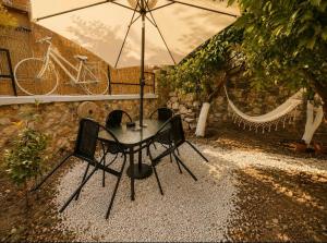 Ein Tisch und Stühle unter einem Regenschirm im Regen in der Unterkunft TheAiryLoft in Mytilini
