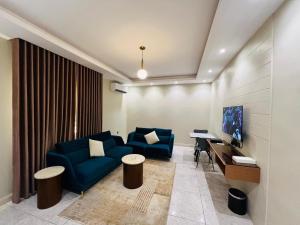 a living room with a blue couch and a desk at شقق سكنية بابو ذر in Medina