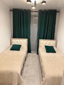 two beds in a room with green curtains at Атлантис in Chon-Sary-Oy +14 photos