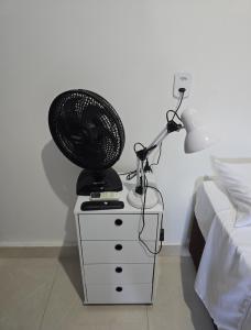 a lamp and a fan on a dresser next to a bed at Microcasa 6 in Lajeado