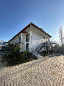 a white house with a staircase and a patio at Атлантис in Chon-Sary-Oy