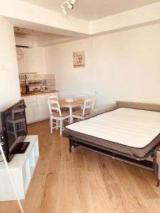 a bedroom with a bed and a table and a kitchen at Casa Di Luce con Parcheggio Privato Interno Gratuito in Montesilvano