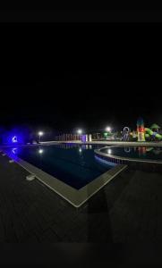 a swimming pool lit up at night with lights at Атлантис in Chon-Sary-Oy