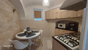 a small kitchen with a table and a stove at Casa Iacob in Sighişoara