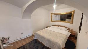 a small bedroom with a bed and a mirror at Casa Iacob in Sighişoara