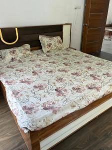 a bed with a floral bedspread and pillows on it at Casa asud Dapoli in Dapoli