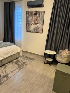 a bedroom with a bed and a chair at F&F Villa in Tema