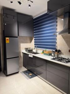 a kitchen with black cabinets and a stainless steel refrigerator at F&F Villa in Tema